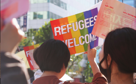 Woman holding sign 'refugees welcome'